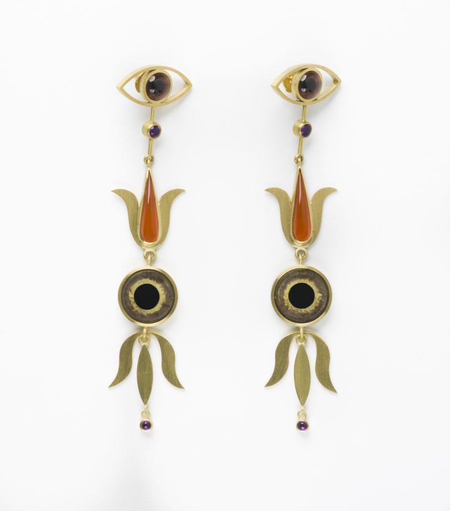 Each long earring has an eye at the top followed by a flowere nf then the moon and another flower. the colours are greens and oranges.